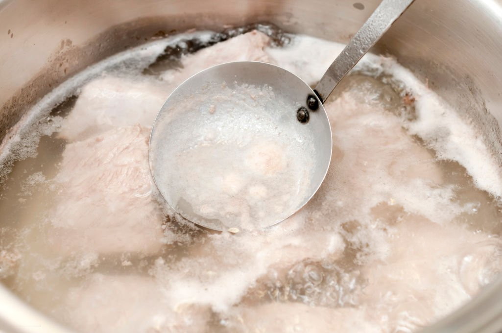 Skimming scum (impurities) from a stock.